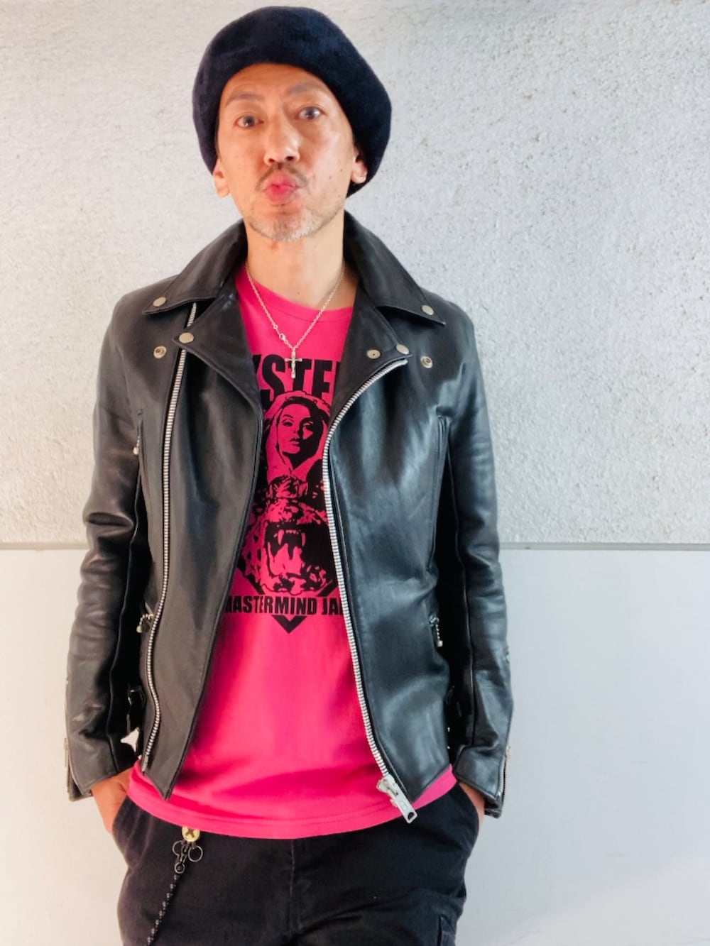 ブラック系のライダースジャケット、ピンク系のTシャツ/カットソー、ブラック系のカーゴパンツを着用したメンズの春コーディネートの2枚目の写真
