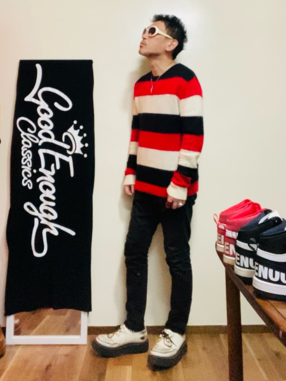 レッド系のニット/セーター、ブラック系のパンツ、ホワイト系のその他シューズを着用したメンズの冬コーディネートの3枚目の写真