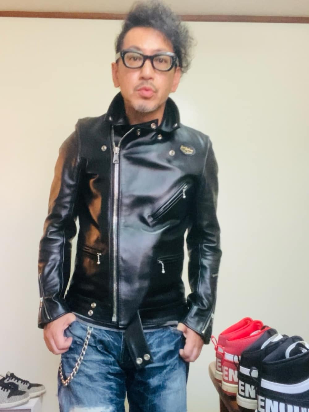 ブラック系のライダースジャケット、ブルー系のデニムパンツ、ブラック系のスニーカーを着用したメンズの秋コーディネートの4枚目の写真