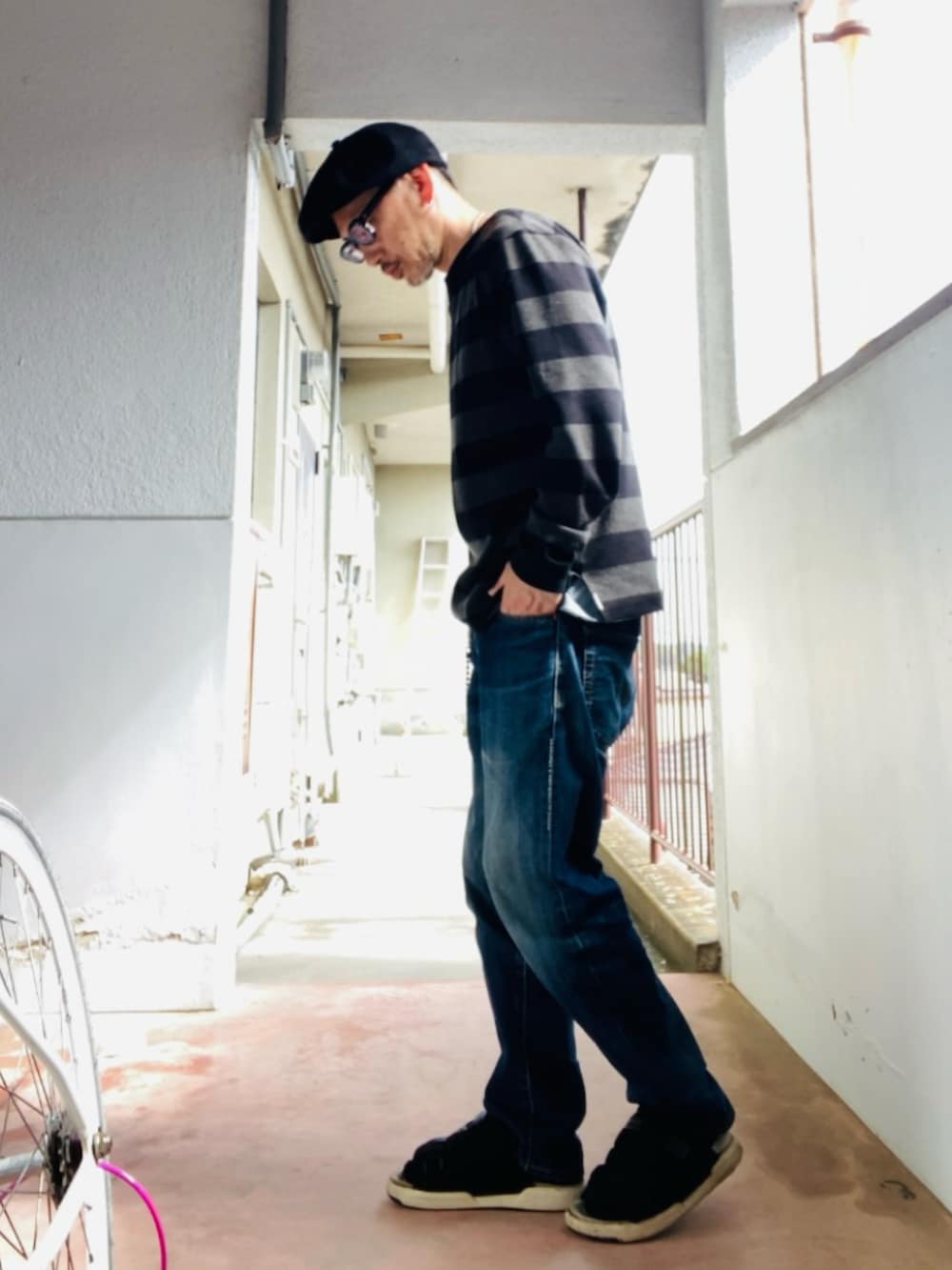グレー系のニット/セーター、ブルー系のデニムパンツ、ブラック系のサンダルを着用したメンズの春コーディネートの3枚目の写真