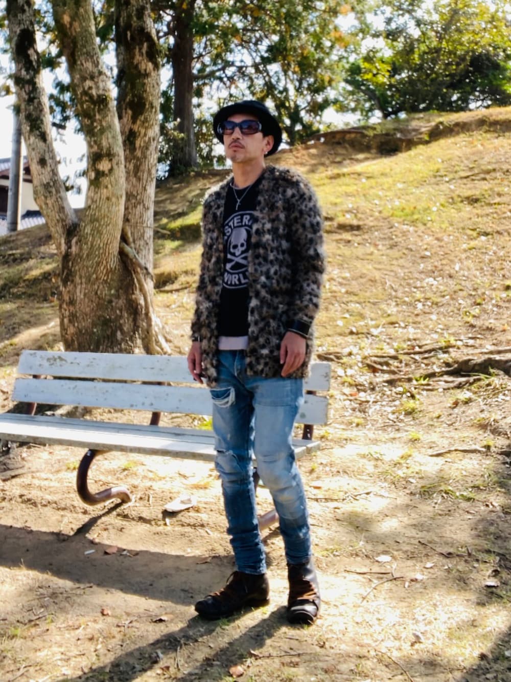 ブラウン系のカーディガン/ボレロ、ブラック系のTシャツ/カットソー、ブルー系のデニムパンツを着用したメンズの秋コーディネートの5枚目の写真