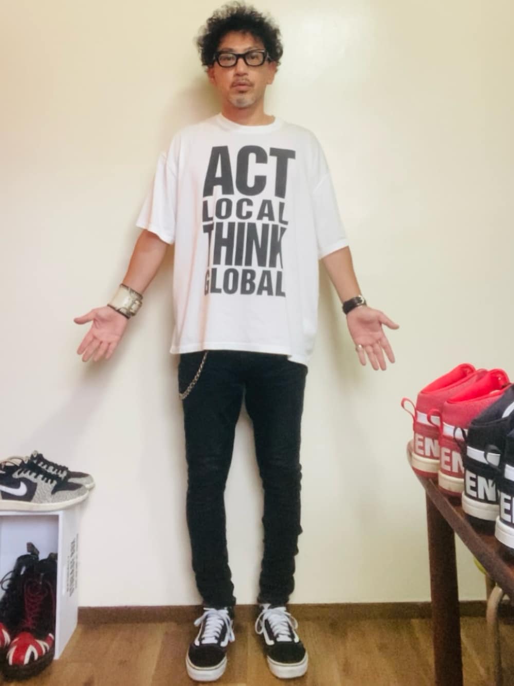 ブラック系のデニムパンツ、ブラック系のスニーカー、ホワイト系のTシャツ/カットソーを着用したメンズの秋コーディネートの3枚目の写真