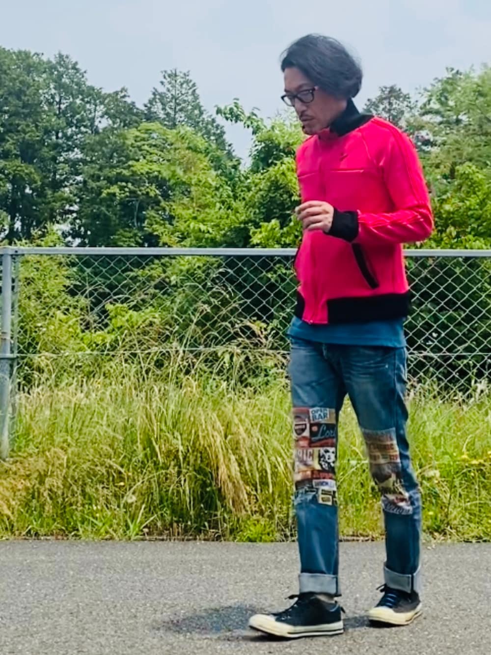 ピンク系のジャージ、ブルー系のデニムパンツ、ブラック系のスニーカーを着用したメンズの春コーディネートの4枚目の写真