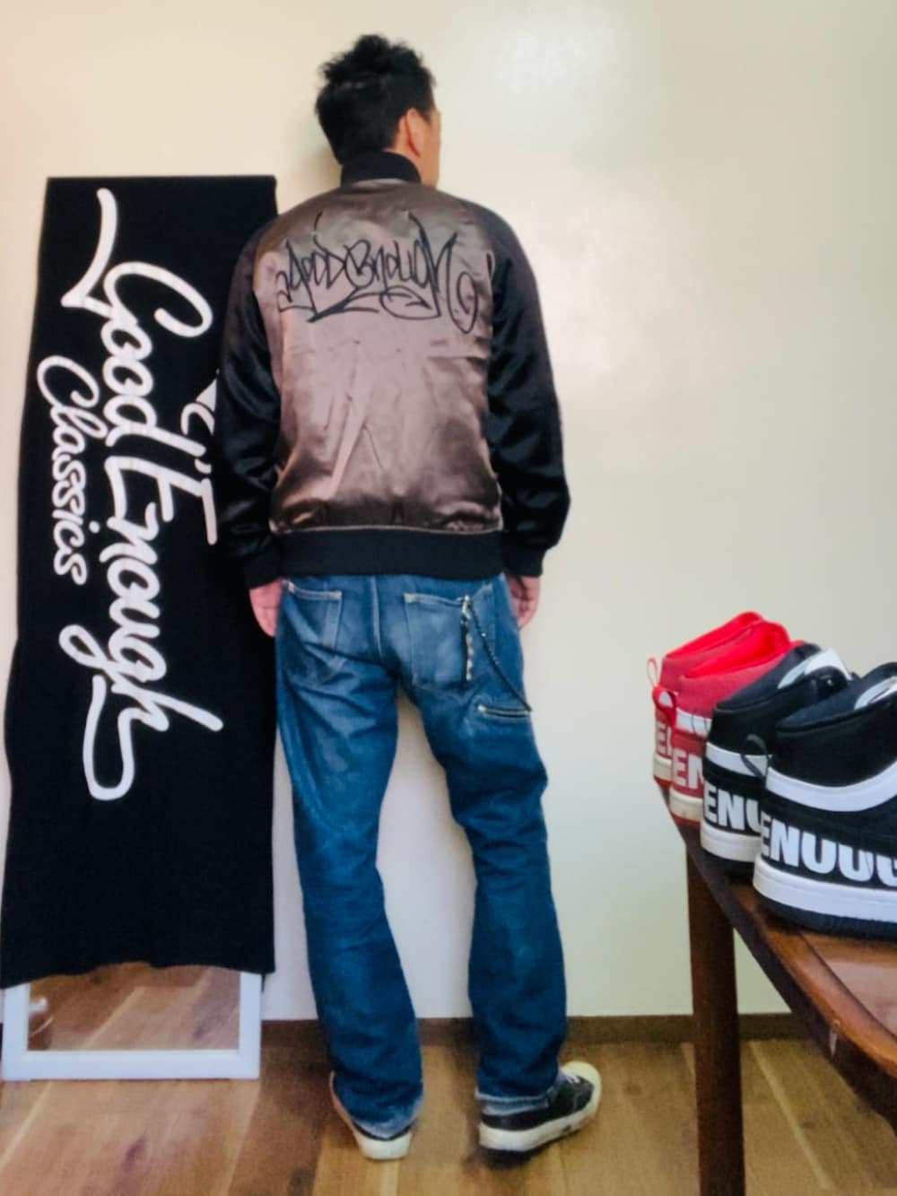 ブラック系のスカジャン、ブルー系のデニムパンツ、ブラック系のスニーカーを着用したメンズの冬コーディネートの3枚目の写真