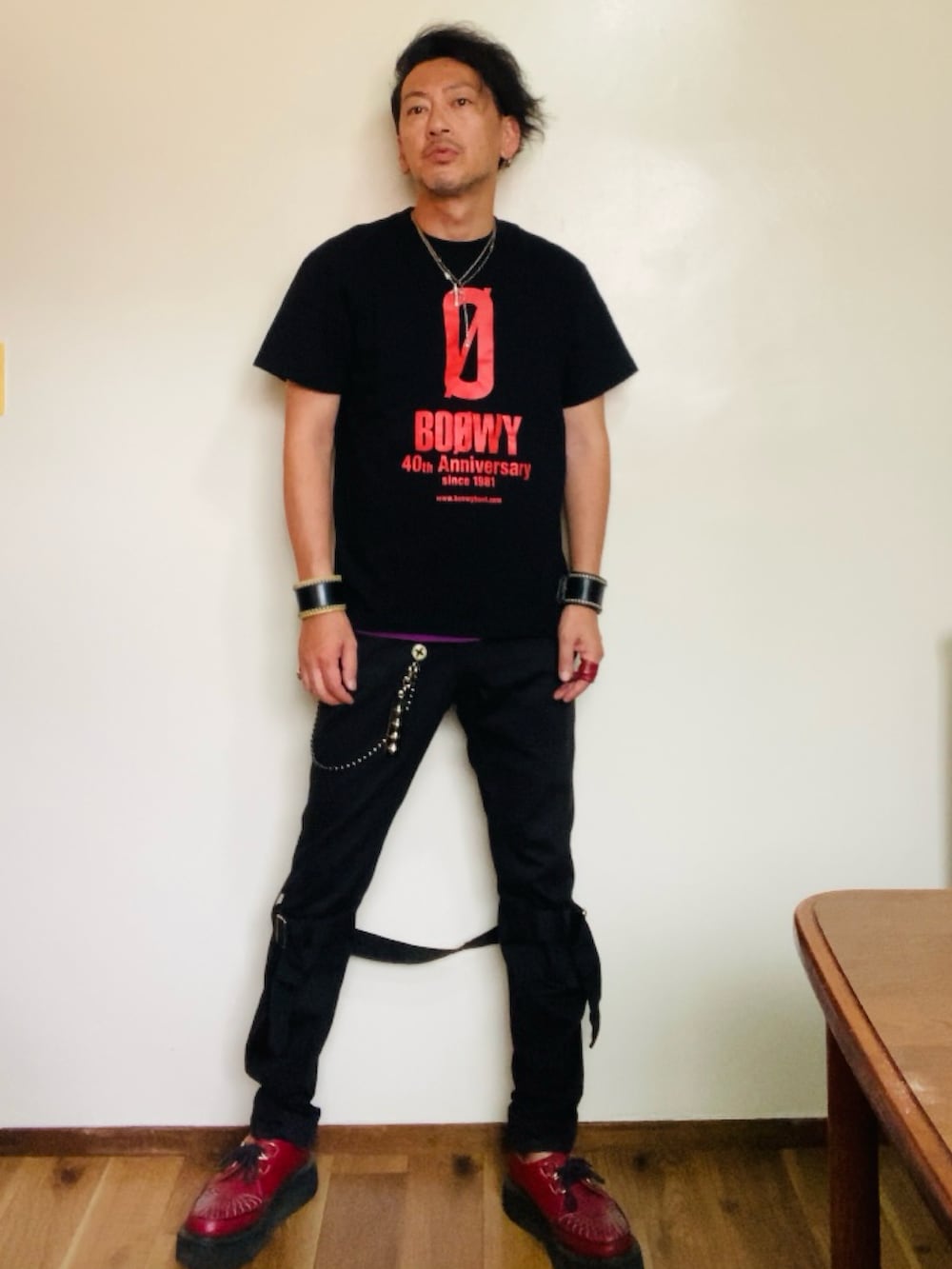 ブラック系のTシャツ/カットソー、ブラック系のその他パンツ、レッド系のブーツを着用したメンズの夏コーディネートの5枚目の写真