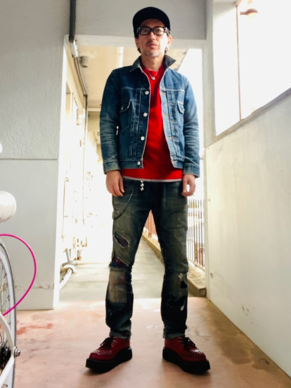 ブルー系のデニムジャケット、レッド系のニット/セーター、ブルー系のデニムパンツを着用したメンズの冬コーディネートの3枚目の写真