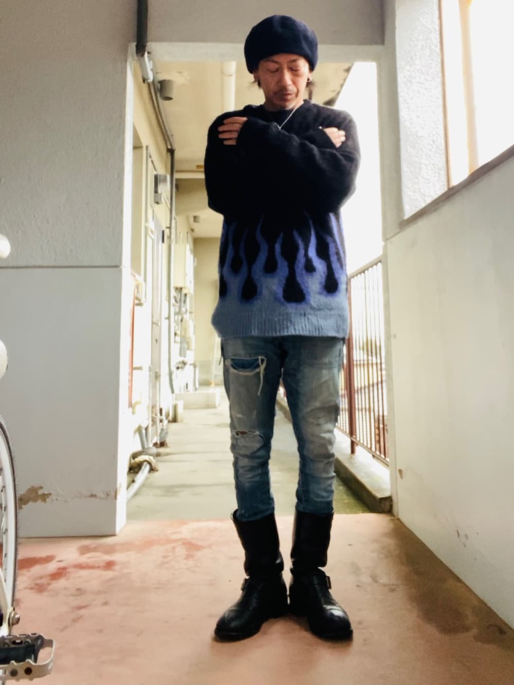 ブラック系のニット/セーター、ブルー系のデニムパンツ、ブラック系のブーツを着用したメンズの冬コーディネートの3枚目の写真
