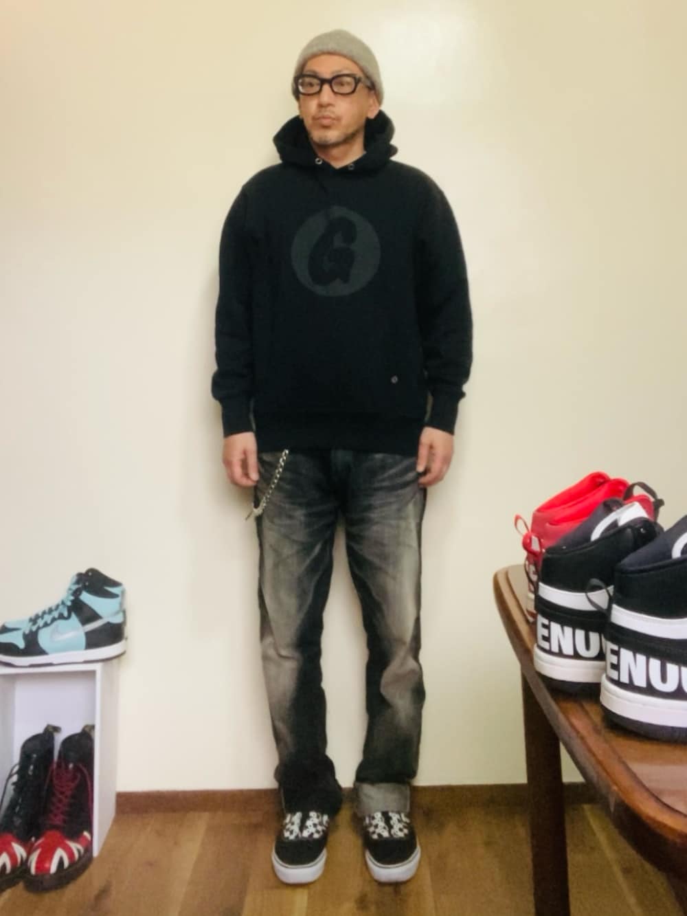 ブラック系のパーカー、ブラック系のデニムパンツ、ブラック系のスニーカーを着用したメンズの春コーディネートの3枚目の写真