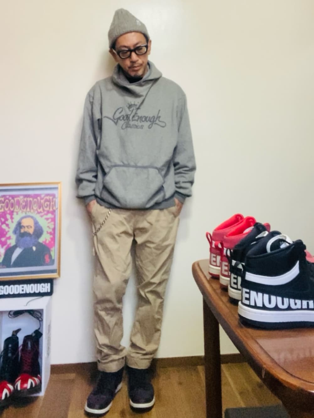 グレー系のパーカー、ベージュ系のチノパンツ、パープル系のスニーカーを着用したメンズの秋コーディネートの2枚目の写真
