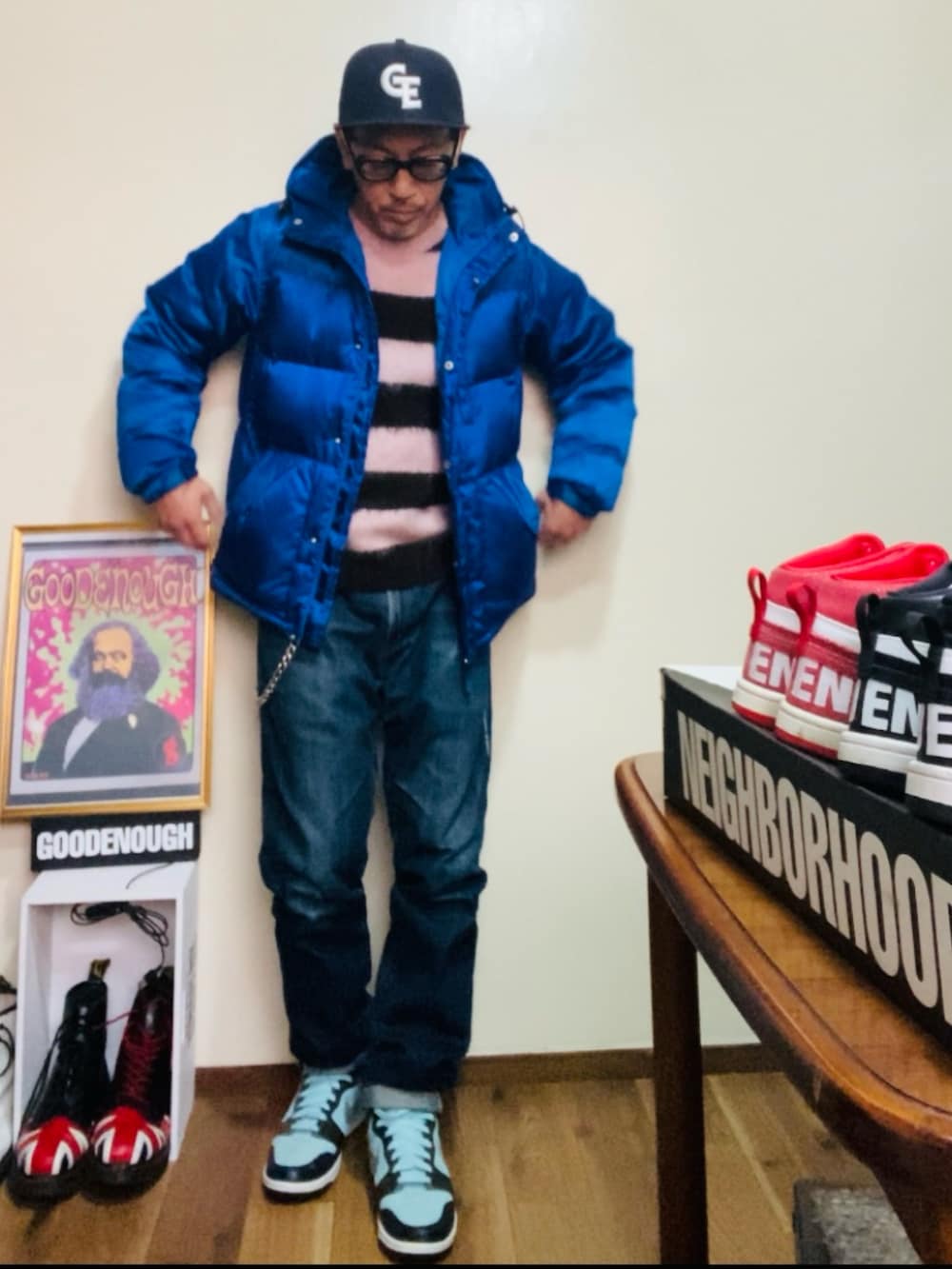 ブルー系のダウンジャケット/コート、ピンク系のニット/セーター、ブルー系のデニムパンツを着用したメンズの冬コーディネートの4枚目の写真