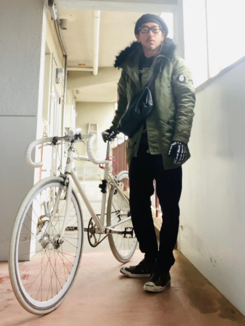 グリーン系のミリタリージャケット、ブラック系のその他パンツ、グリーン系のスニーカーを着用したメンズの冬コーディネートの2枚目の写真