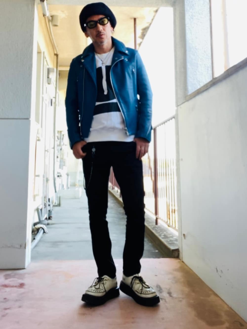 ブルー系のライダースジャケット、ホワイト系のスウェット、ブラック系のパンツを着用したメンズの冬コーディネートの4枚目の写真