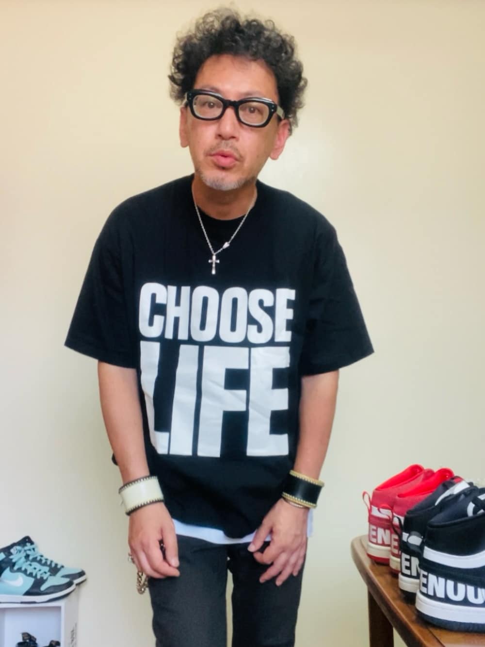 ブラック系のTシャツ/カットソー、ブラック系のパンツ、ホワイト系のスリッポンを着用したメンズの夏コーディネートの3枚目の写真