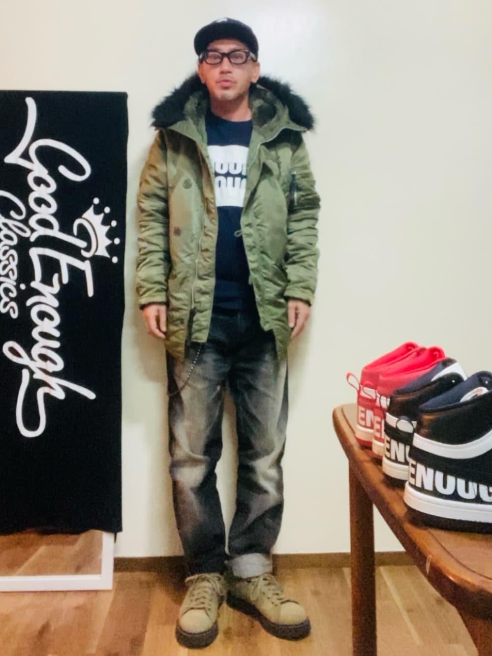 ブルー系のTシャツ/カットソー、グリーン系のミリタリージャケット、ブラック系のデニムパンツを着用したメンズの秋コーディネートの3枚目の写真