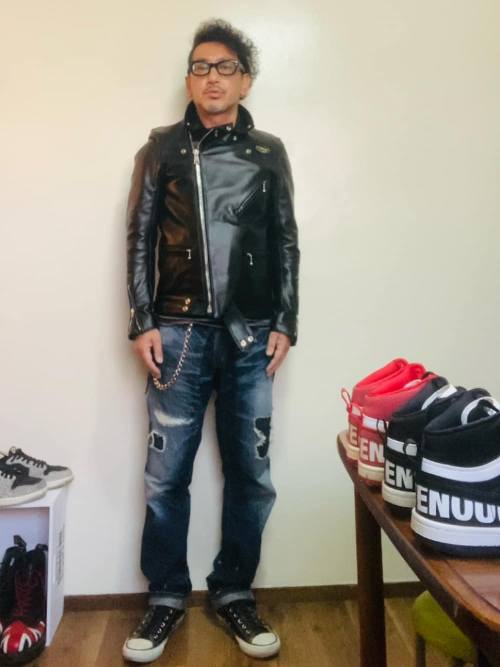ブラック系のライダースジャケット、ブルー系のデニムパンツ、ブラック系のスニーカーを着用したメンズの秋コーディネートの3枚目の写真