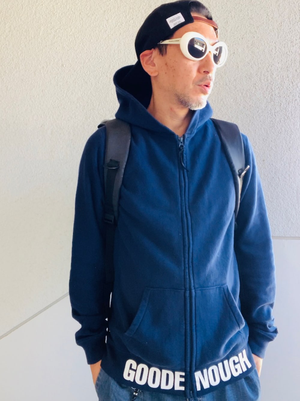 ブルー系のパーカー、ブルー系のデニムパンツ、ブラック系のバックパック/リュックを着用したメンズの秋コーディネートの2枚目の写真