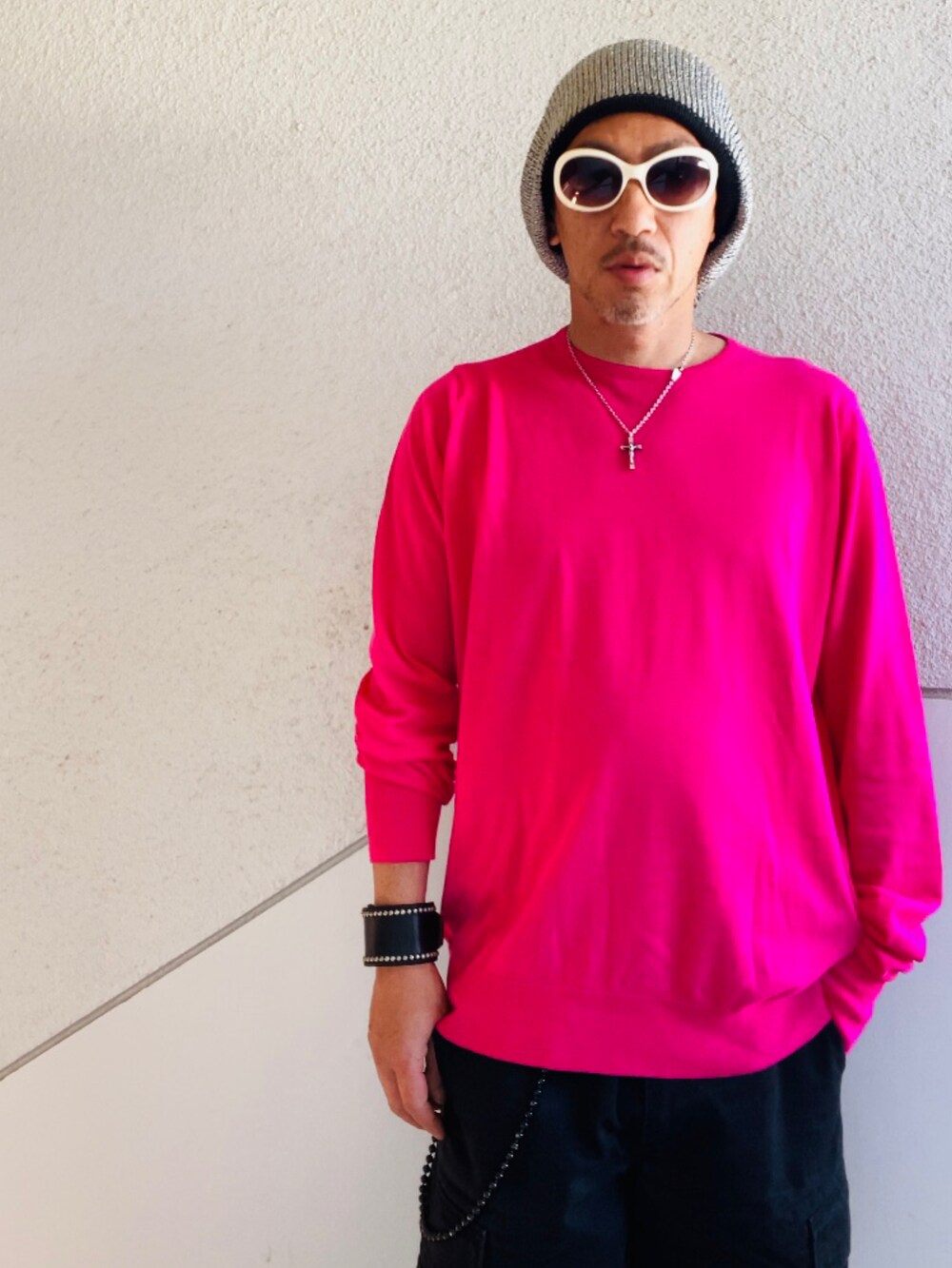 ピンク系のニット/セーター、ブラック系のカーゴパンツ、ブラック系のサンダルを着用したメンズの夏コーディネートの2枚目の写真