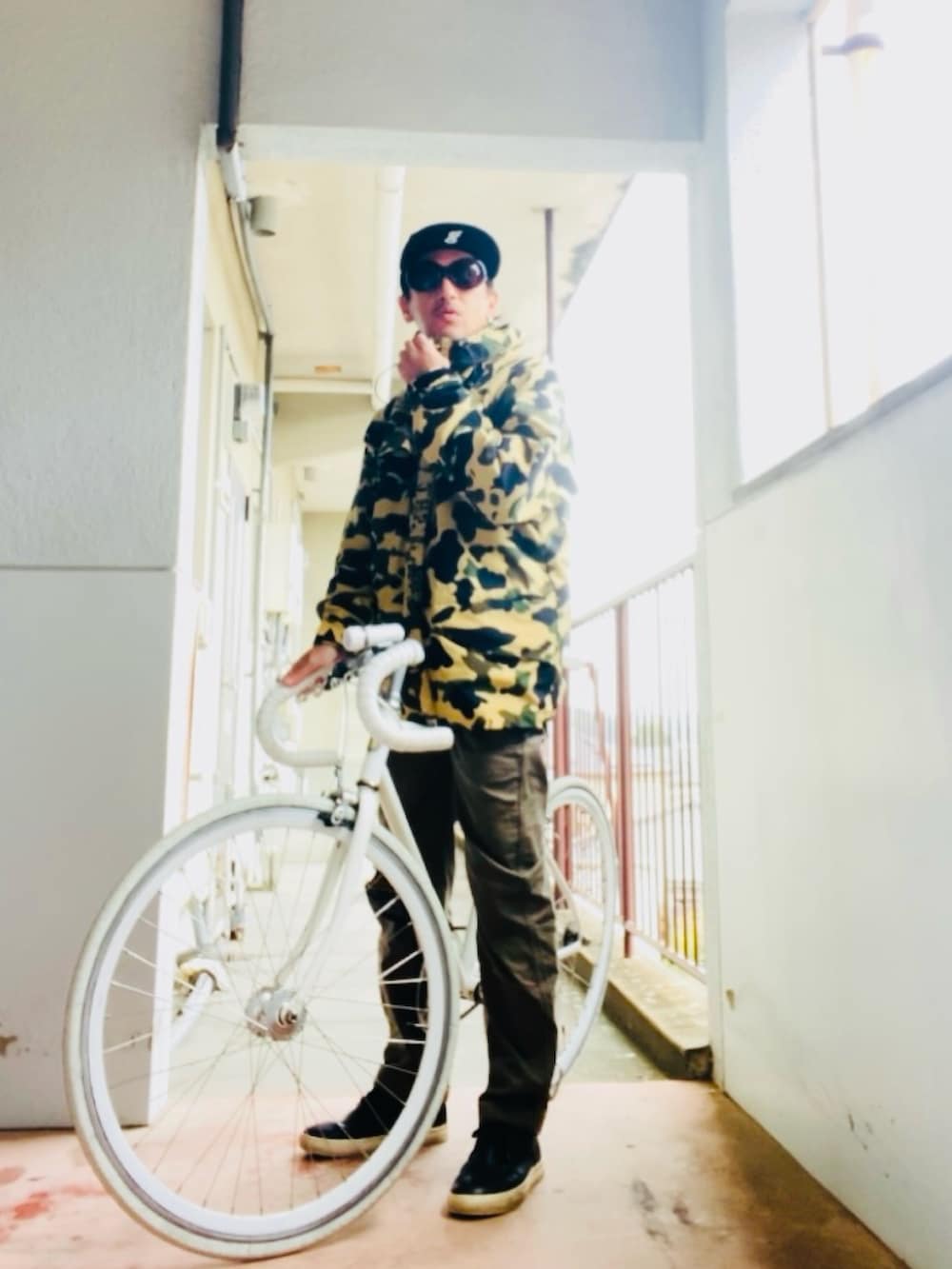 イエロー系のマウンテンパーカー、グリーン系のカーゴパンツ、ブラック系のブーツを着用したメンズの秋コーディネートの3枚目の写真