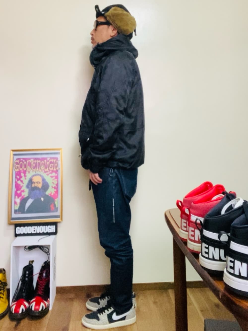 ブラック系のマウンテンパーカー、ブルー系のデニムパンツ、グレー系のスニーカーを着用したメンズの秋コーディネートの3枚目の写真