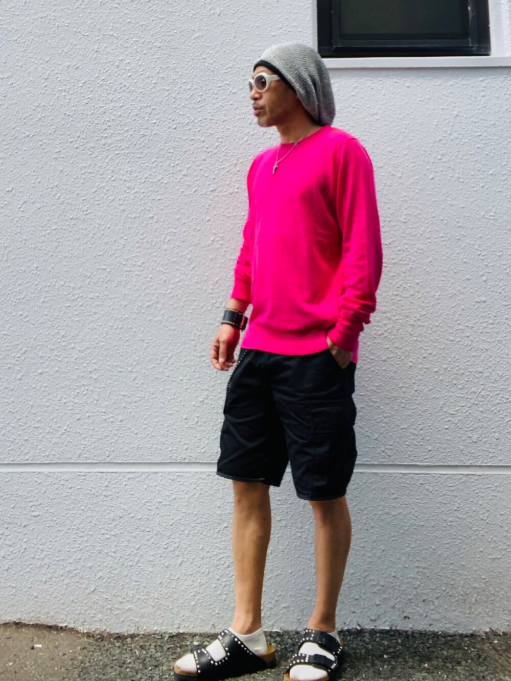 ピンク系のニット/セーター、ブラック系のカーゴパンツ、ブラック系のサンダルを着用したメンズの夏コーディネートの5枚目の写真