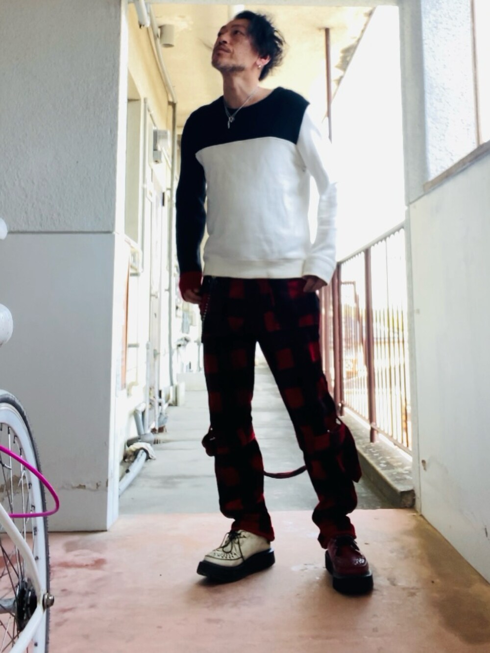 ブラック系のニット/セーター、レッド系のその他パンツ、レッド系のブーツを着用したメンズの春コーディネートの4枚目の写真