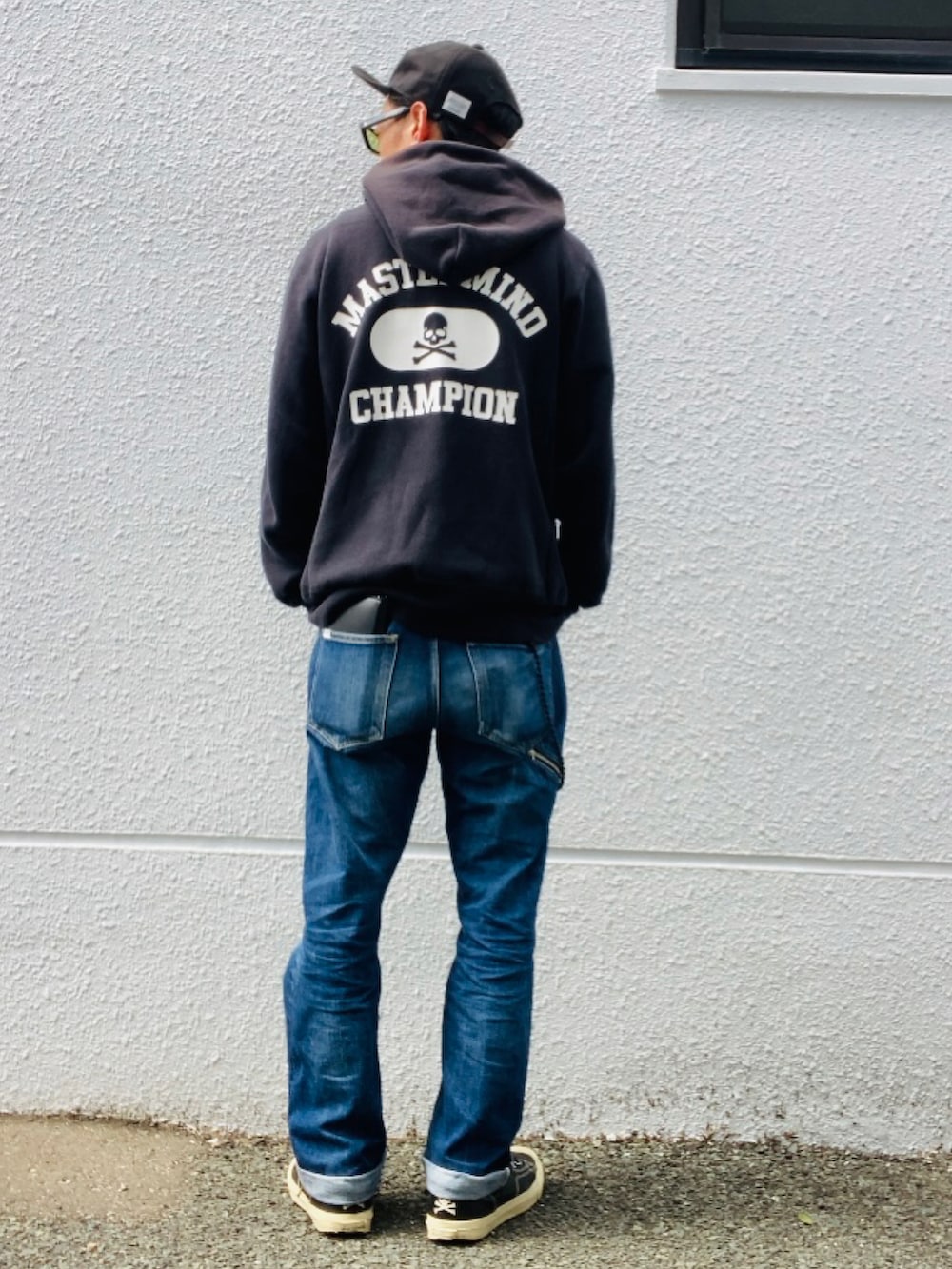 ブラック系のパーカー、ブルー系のデニムパンツ、ブラック系のスニーカーを着用したメンズの春コーディネートの3枚目の写真