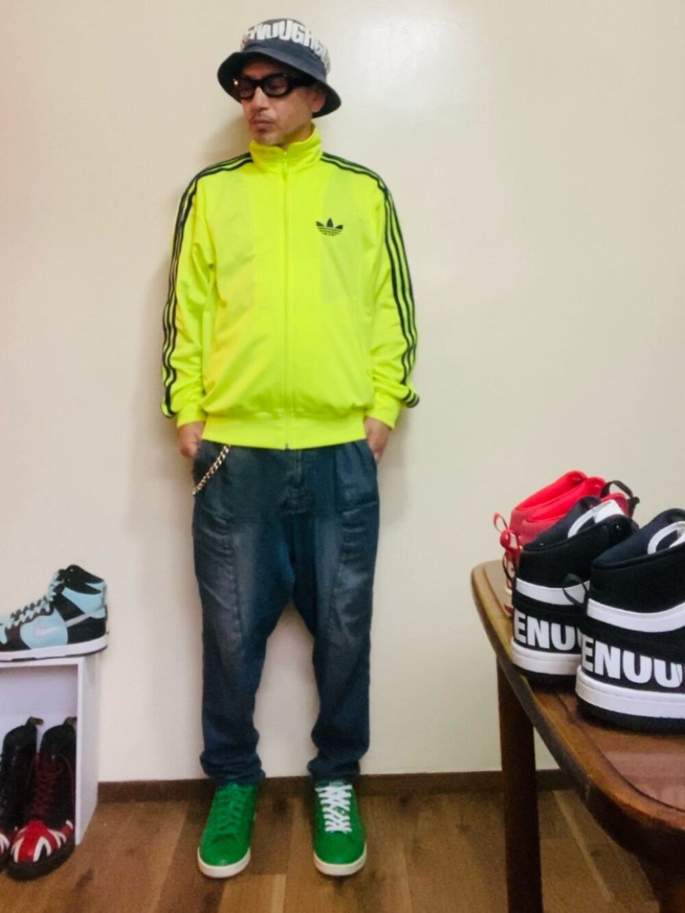 イエロー系のジャージ、ブルー系のデニムパンツ、グリーン系のスニーカーを着用したメンズの春コーディネートの3枚目の写真