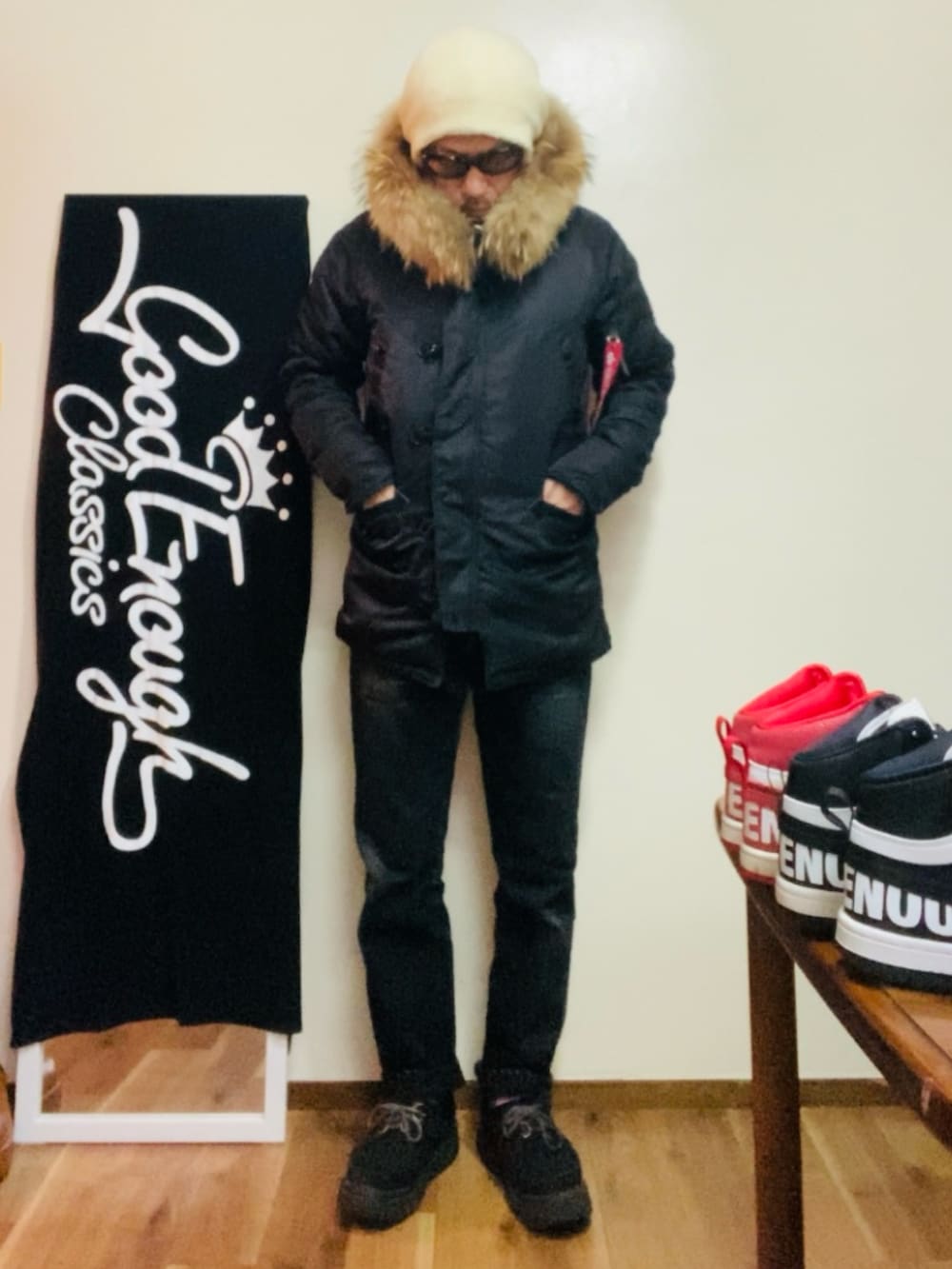 ブラック系のミリタリージャケット、ブラック系のニット/セーター、ブラック系のデニムパンツを着用したメンズの冬コーディネートの2枚目の写真