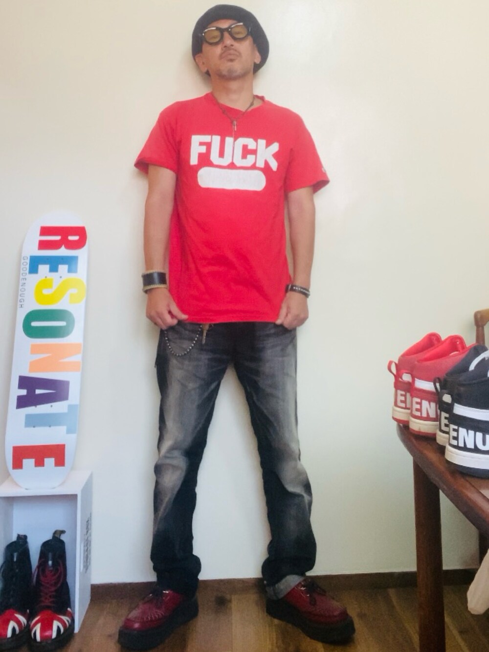 レッド系のTシャツ/カットソー、ブラック系のデニムパンツ、レッド系のブーツを着用したメンズの夏コーディネートの3枚目の写真