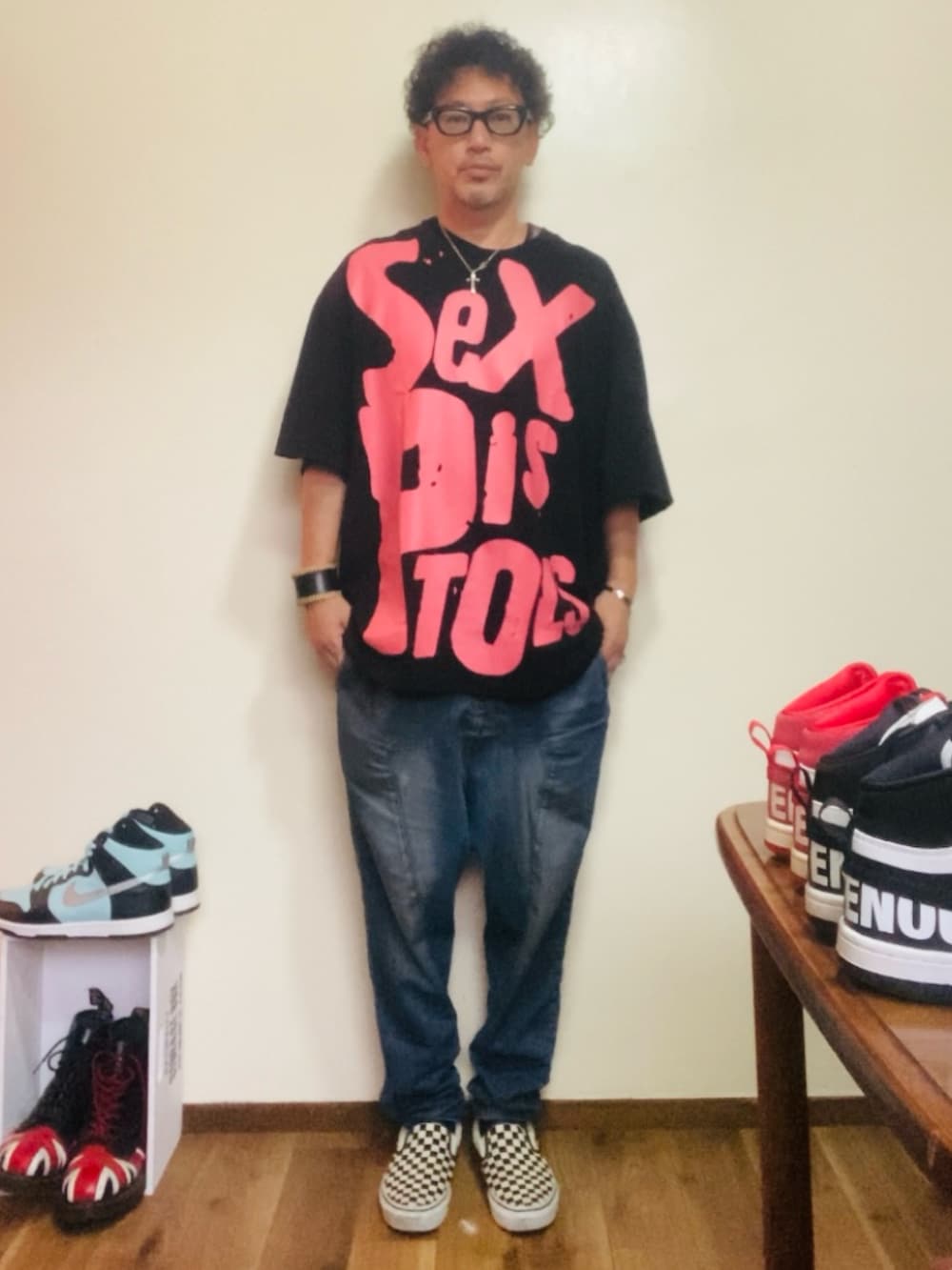 ブラック系のTシャツ/カットソー、ブルー系のデニムパンツ、ホワイト系のスリッポンを着用したメンズの夏コーディネートの3枚目の写真
