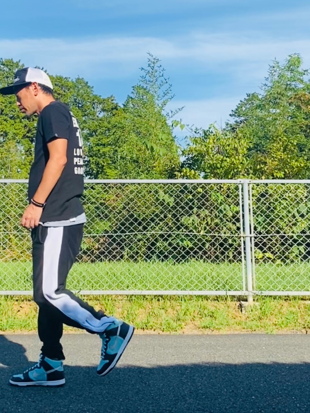 ブラック系のTシャツ/カットソー、ブラック系のスウェットパンツ、グリーン系のスニーカーを着用したメンズの秋コーディネートの4枚目の写真