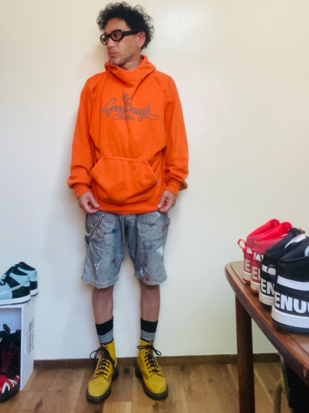 オレンジ系のパーカー、グレー系のデニムパンツ、イエロー系のブーツを着用したメンズの夏コーディネートの4枚目の写真