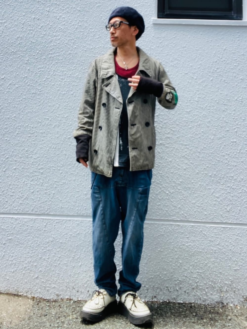 グレー系のピーコート、レッド系のタンクトップ、ブラック系のタンクトップを着用したメンズの春コーディネートの5枚目の写真