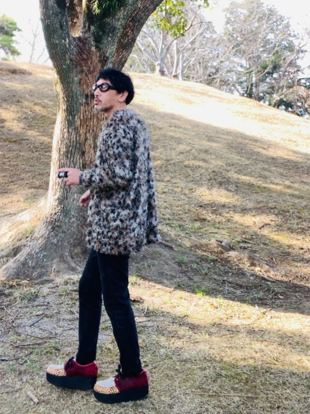 ブラウン系のカーディガン/ボレロ、ブラック系のTシャツ/カットソー、ブラック系のデニムパンツを着用したメンズの春コーディネートの3枚目の写真