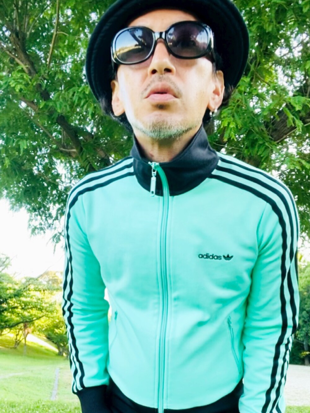 グリーン系のジャージ、ブルー系のタンクトップ、ブルー系のその他パンツを着用したメンズの夏コーディネートの4枚目の写真