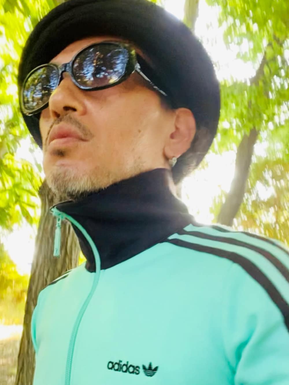 グリーン系のジャージ、ブルー系のタンクトップ、ブルー系のその他パンツを着用したメンズの夏コーディネートの2枚目の写真