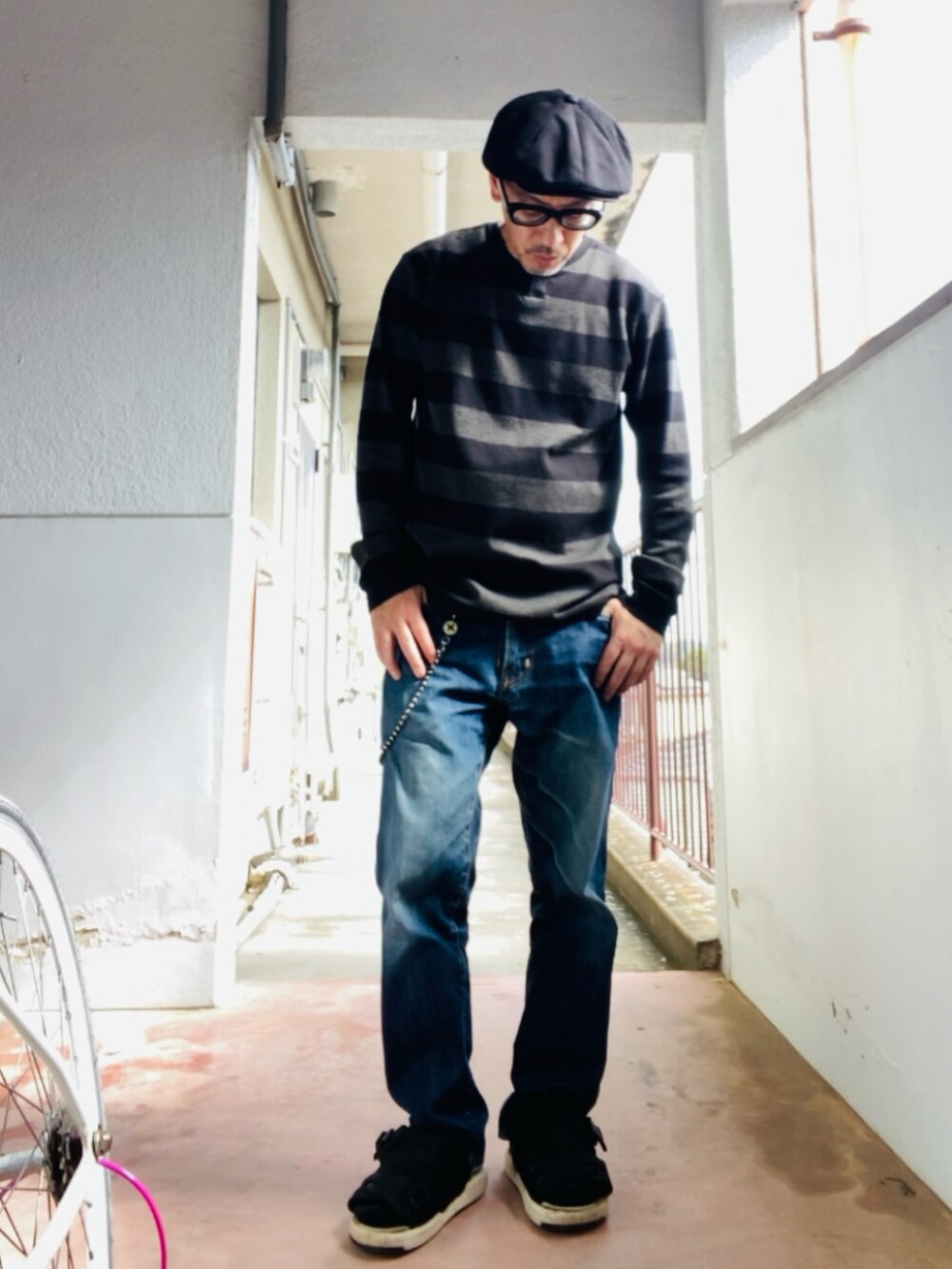 グレー系のニット/セーター、ブルー系のデニムパンツ、ブラック系のサンダルを着用したメンズの春コーディネートの4枚目の写真