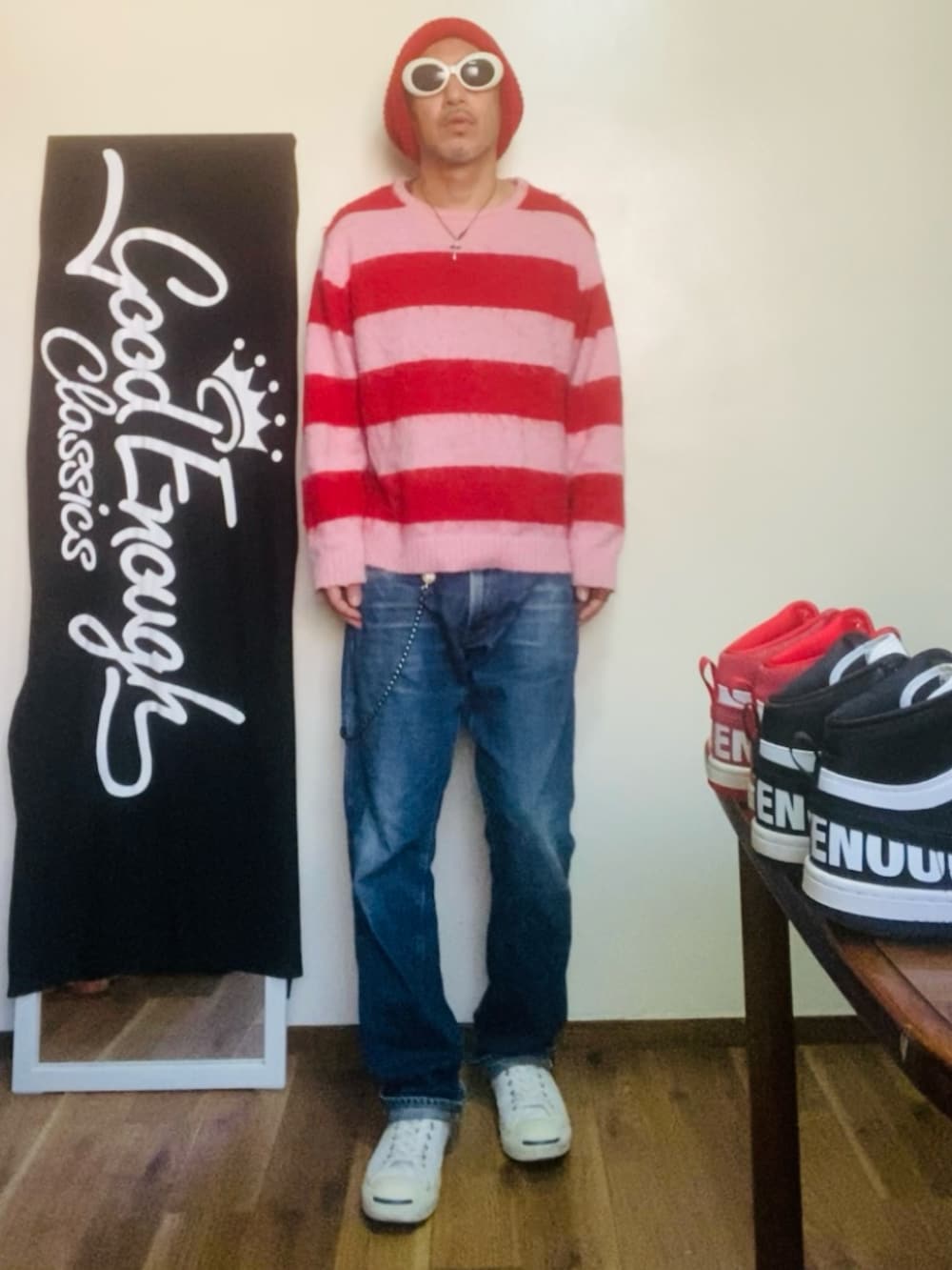 ピンク系のニット/セーター、ブルー系のデニムパンツ、ホワイト系のスニーカーを着用したメンズの秋コーディネートの2枚目の写真