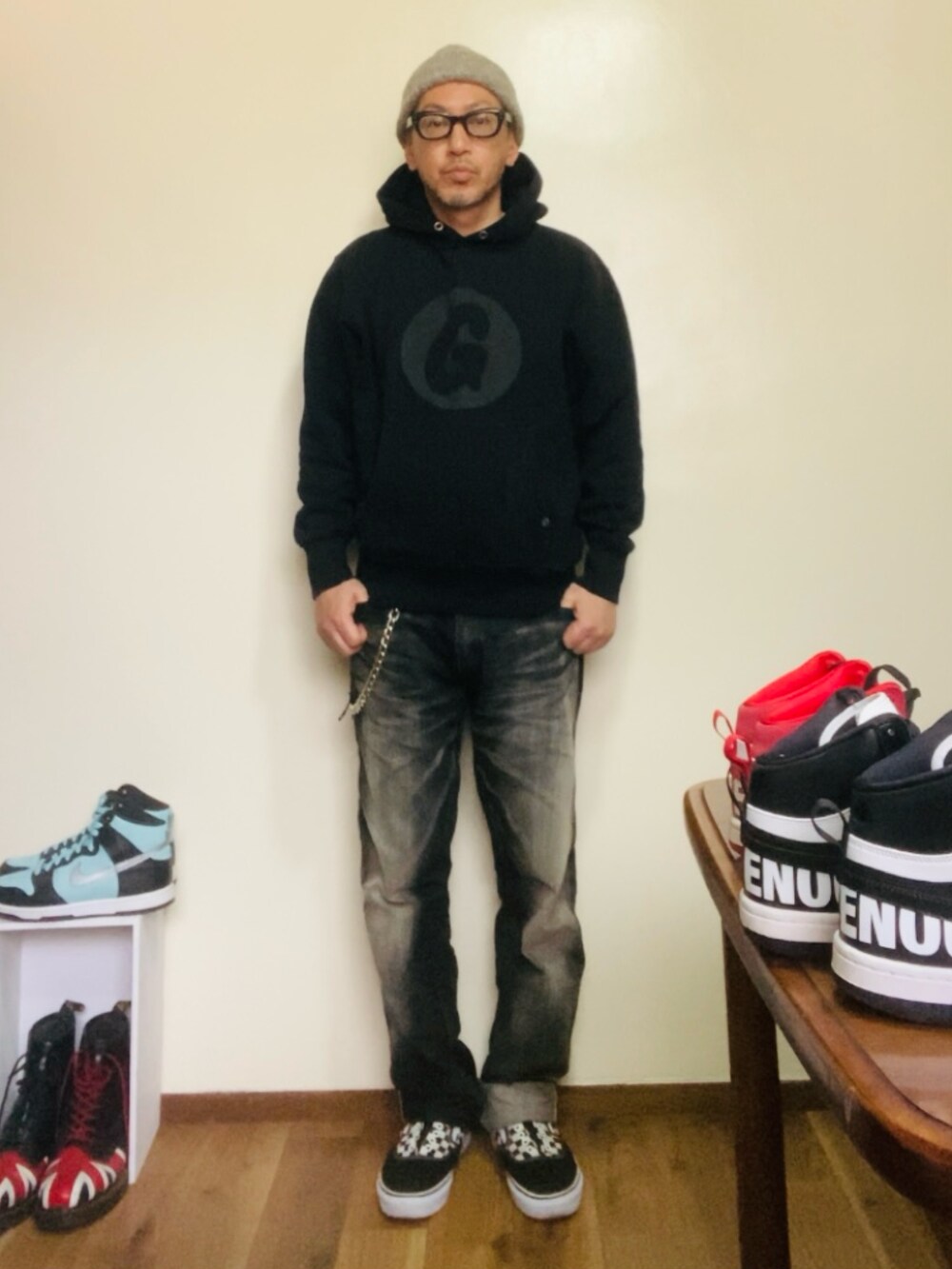 ブラック系のパーカー、ブラック系のデニムパンツ、ブラック系のスニーカーを着用したメンズの春コーディネートの4枚目の写真