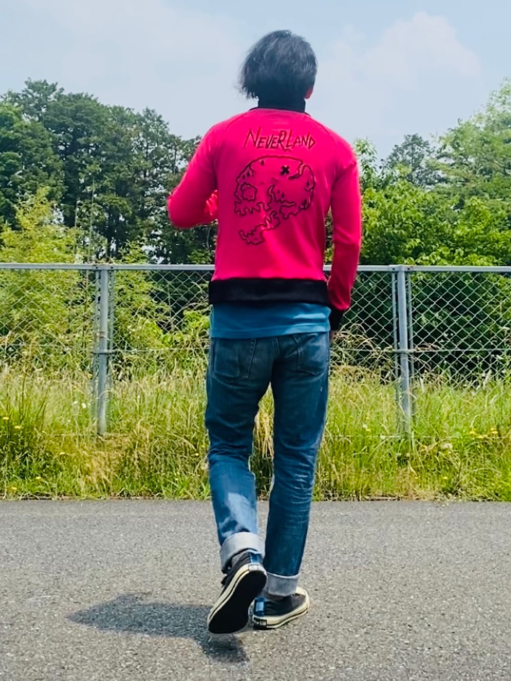 ピンク系のジャージ、ブルー系のデニムパンツ、ブラック系のスニーカーを着用したメンズの春コーディネートの3枚目の写真