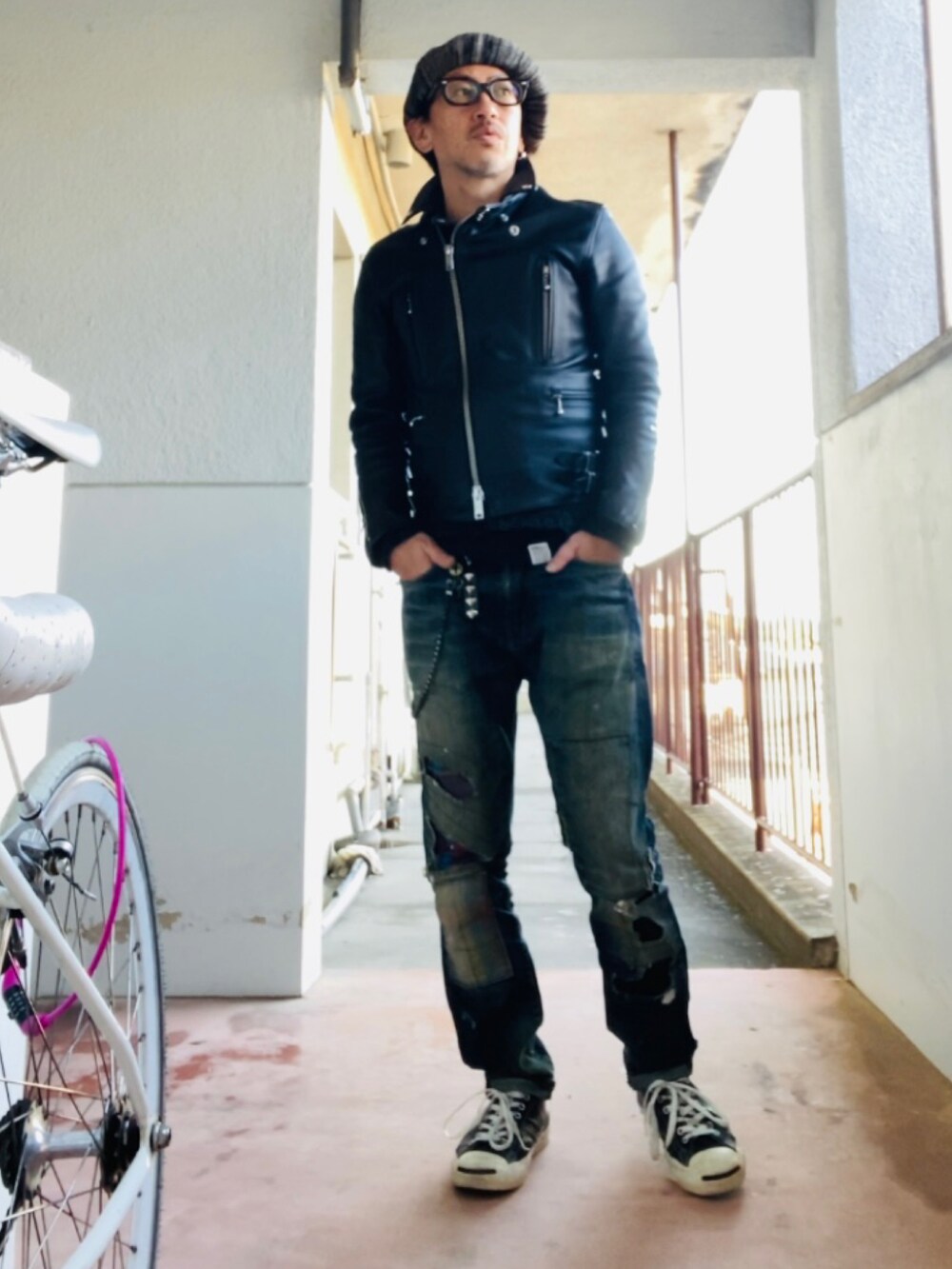 ブルー系のデニムパンツ、ブラック系のライダースジャケット、ブラック系のニット/セーターを着用したメンズの冬コーディネートの4枚目の写真