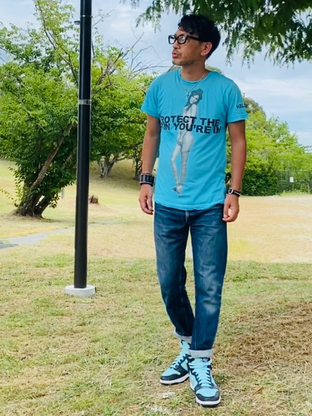 ブルー系のTシャツ/カットソー、ブルー系のデニムパンツ、グリーン系のスニーカーを着用したメンズの夏コーディネートの2枚目の写真