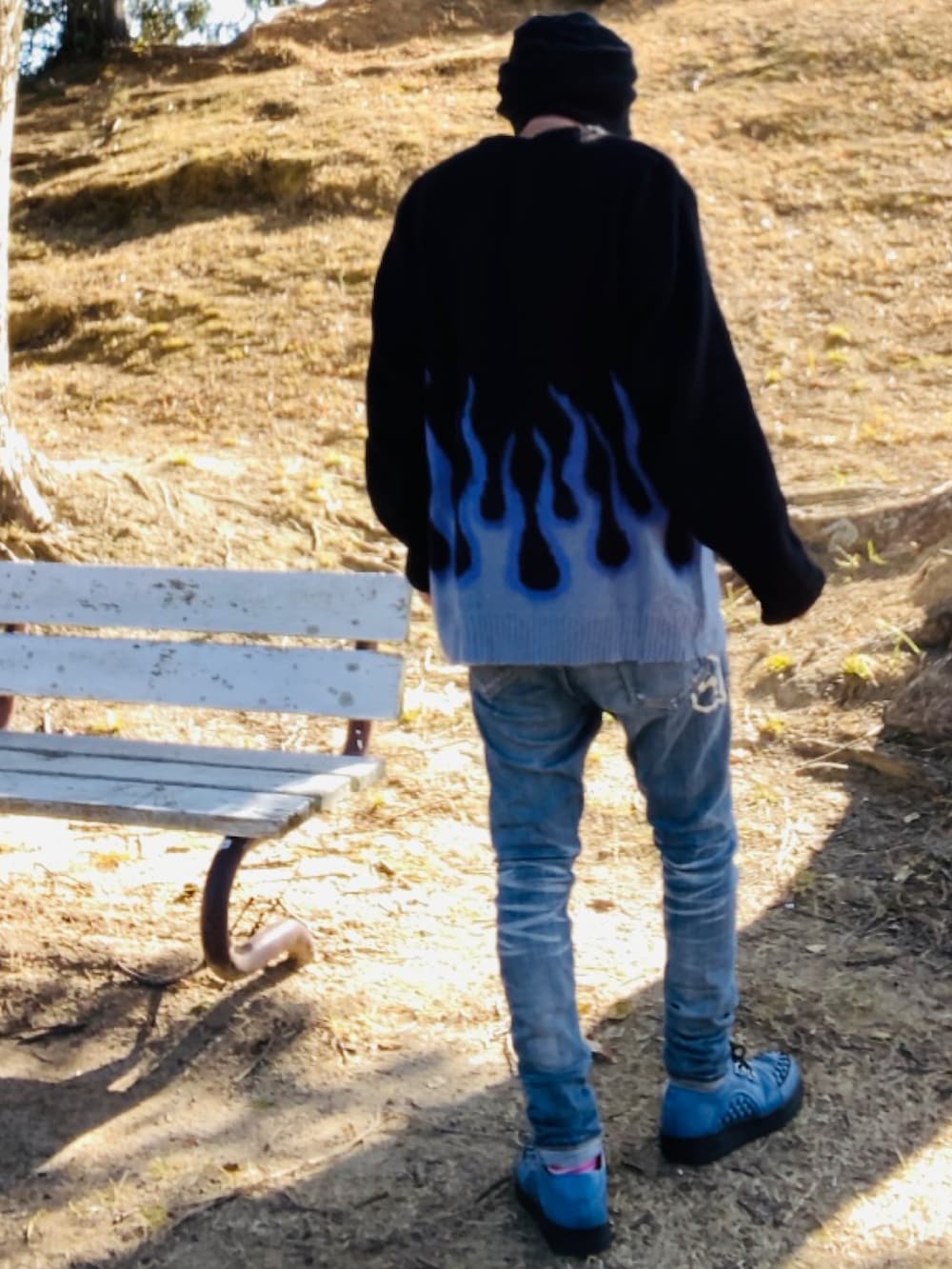 ブラック系のニット/セーター、ブルー系のデニムパンツ、ブルー系のブーツを着用したメンズの冬コーディネートの4枚目の写真