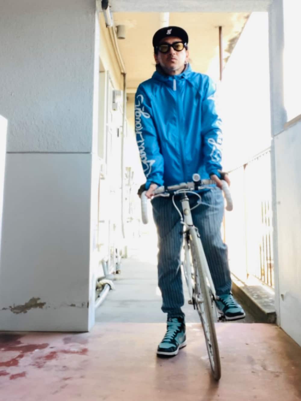 ブルー系のナイロンジャケット、ブルー系のデニムパンツ、グリーン系のスニーカーを着用したメンズの冬コーディネートの2枚目の写真