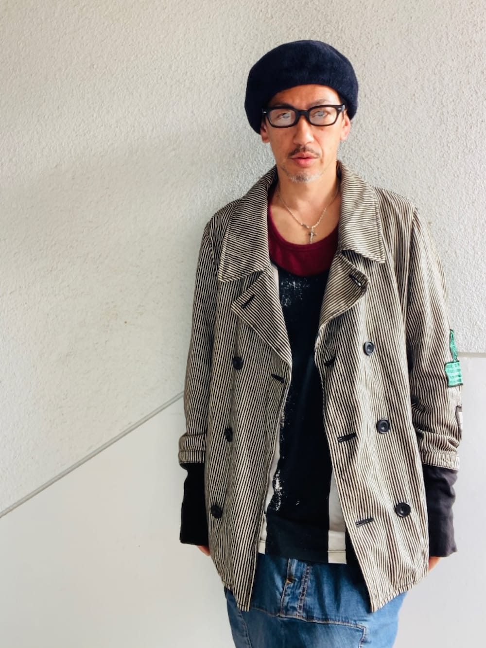 グレー系のピーコート、レッド系のタンクトップ、ブラック系のタンクトップを着用したメンズの春コーディネートの2枚目の写真