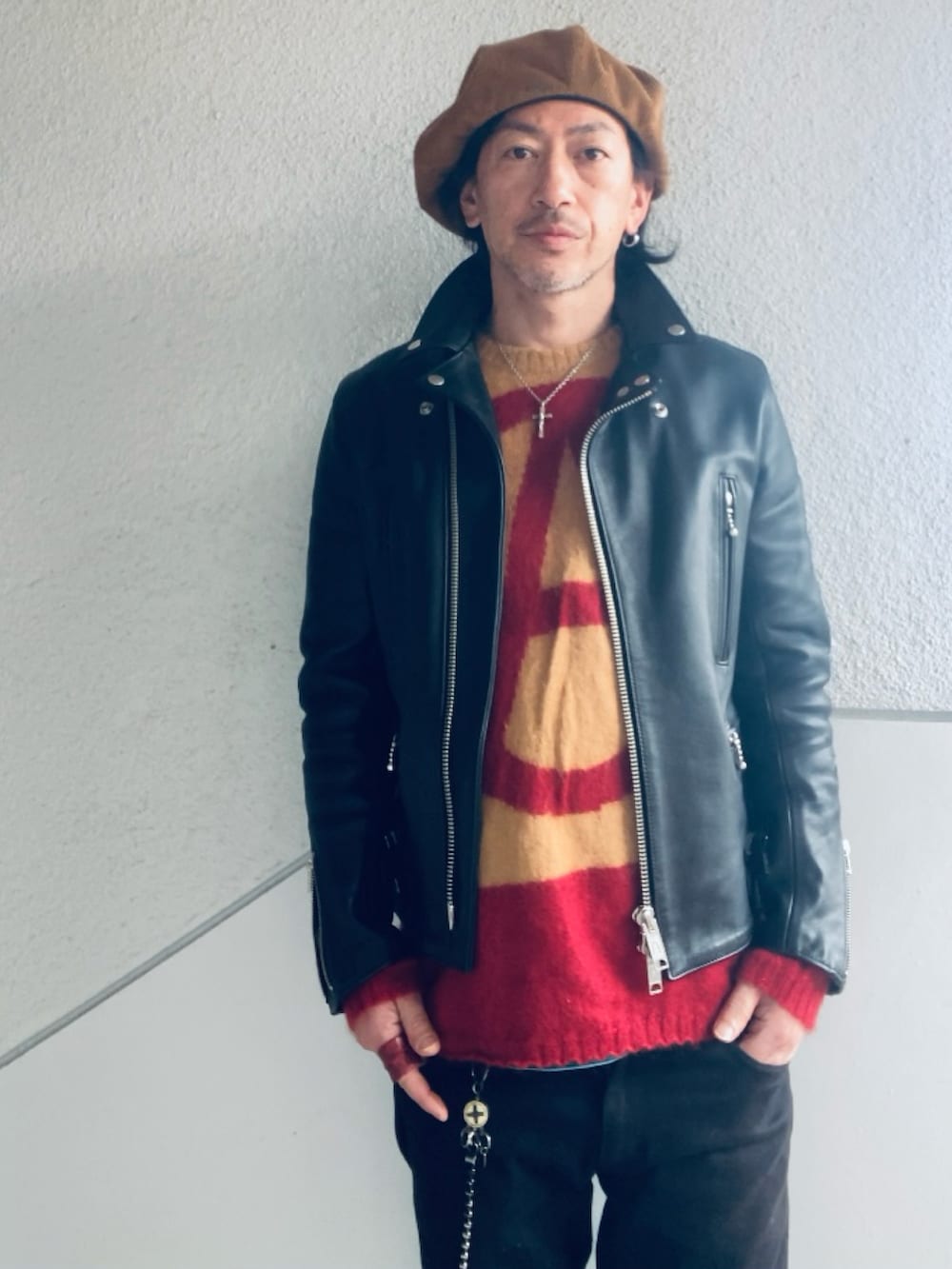 ベージュ系のニット/セーター、ブラック系のライダースジャケット、ブラック系のパンツを着用したメンズの春コーディネートの2枚目の写真