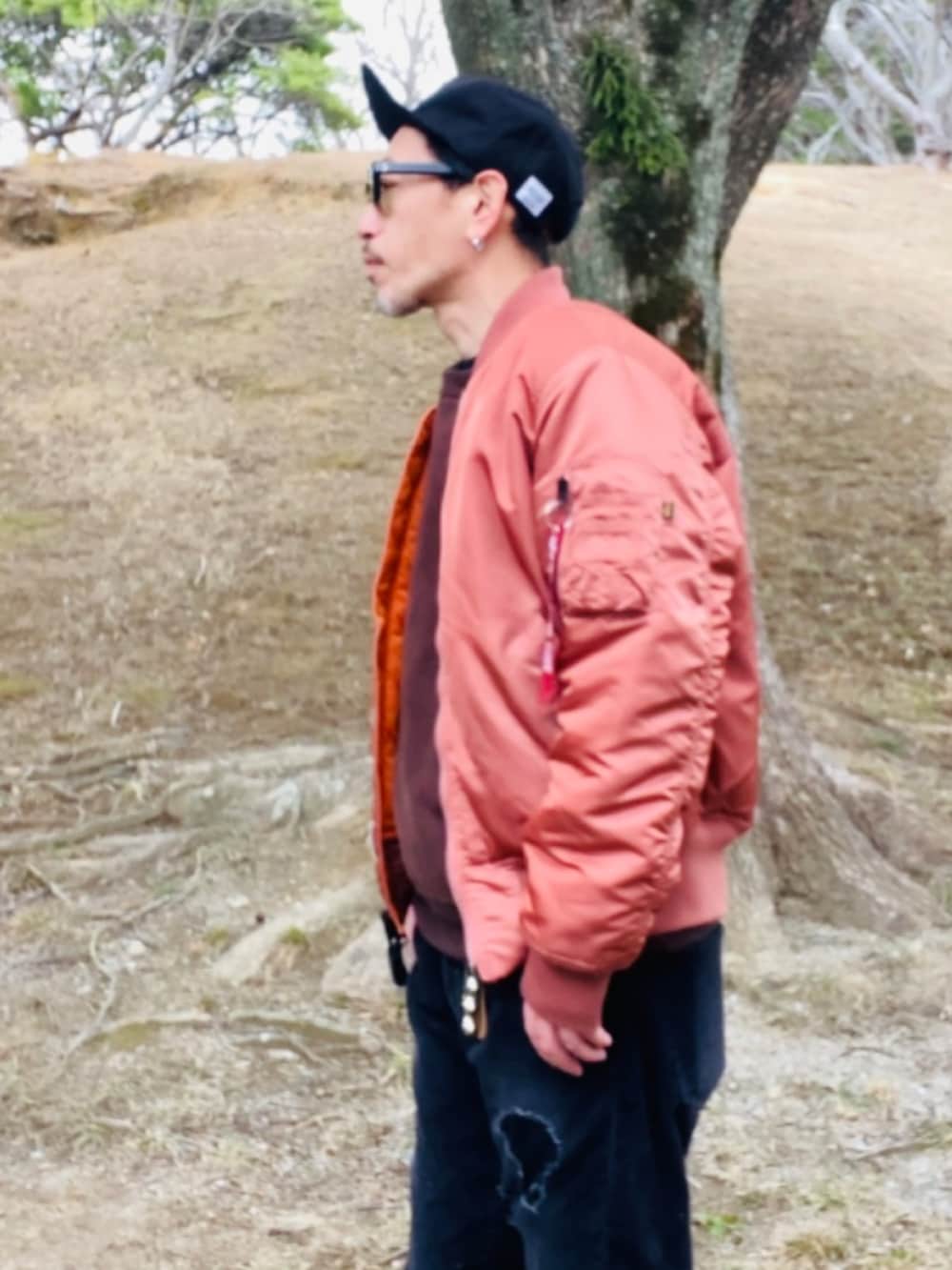 レッド系のMA-1、ブラウン系のスウェット、ブラック系のその他パンツを着用したメンズの冬コーディネートの3枚目の写真