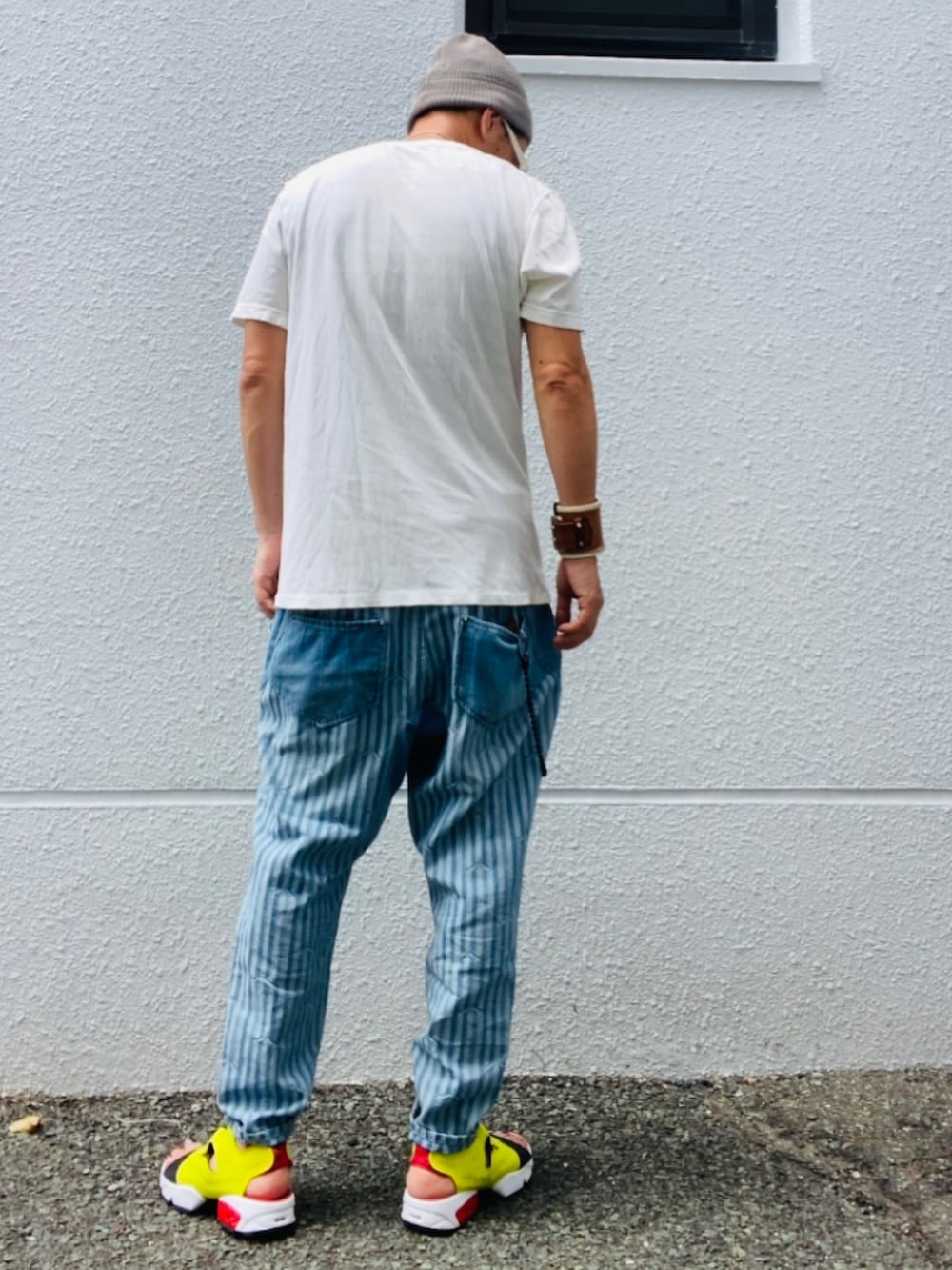 ホワイト系のTシャツ/カットソー、ブルー系のデニムパンツ、イエロー系のサンダルを着用したメンズの夏コーディネートの5枚目の写真