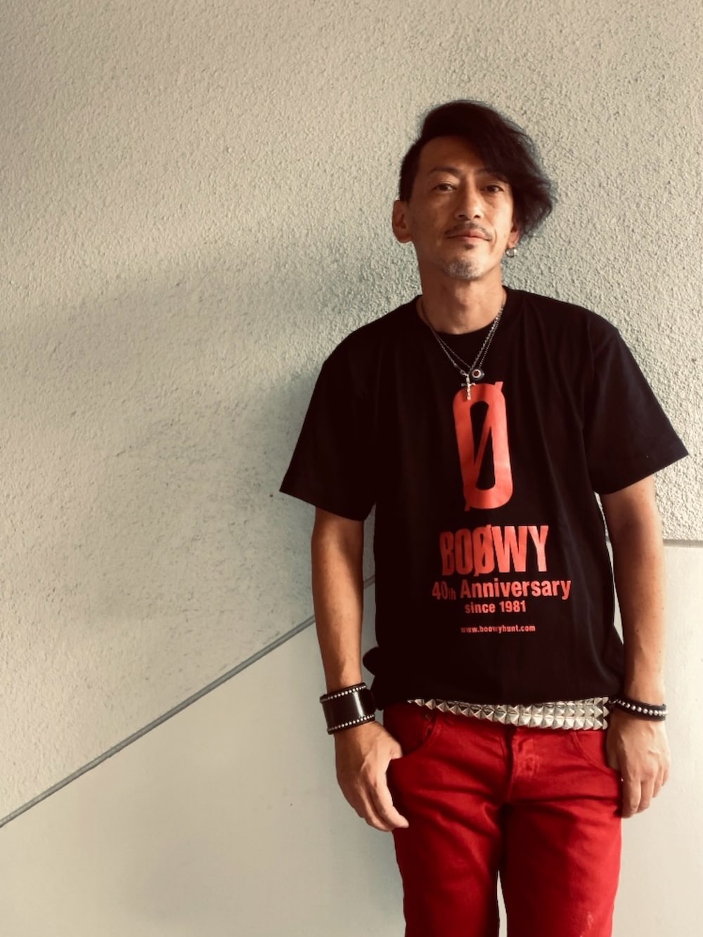 ブラック系のTシャツ/カットソー、レッド系のデニムパンツ、ホワイト系のベルトを着用したメンズの夏コーディネートの3枚目の写真