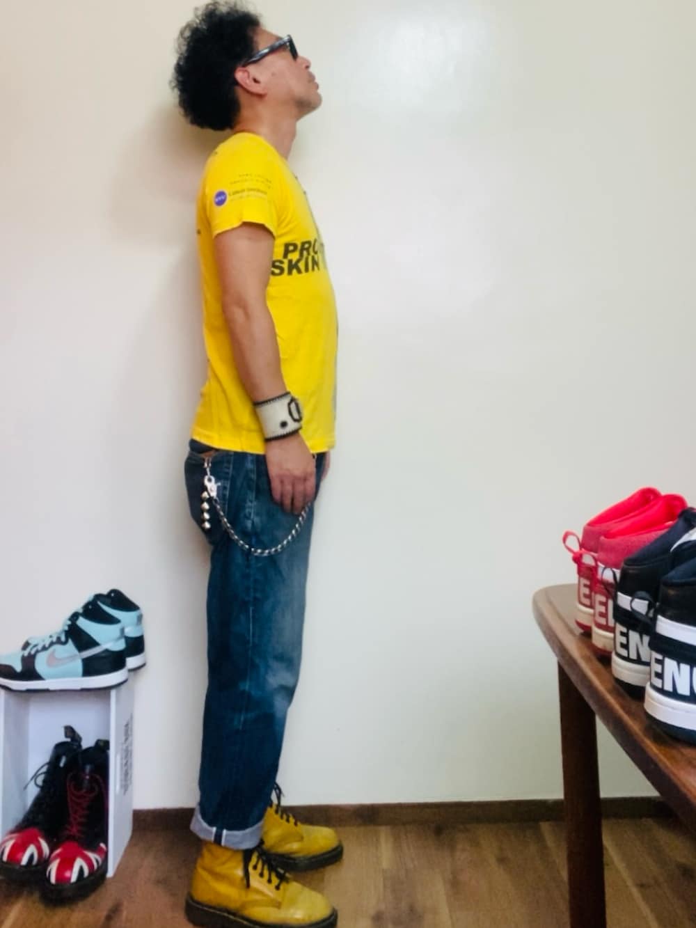 イエロー系のブーツ、イエロー系のTシャツ/カットソー、ブルー系のデニムパンツを着用したメンズの夏コーディネートの3枚目の写真